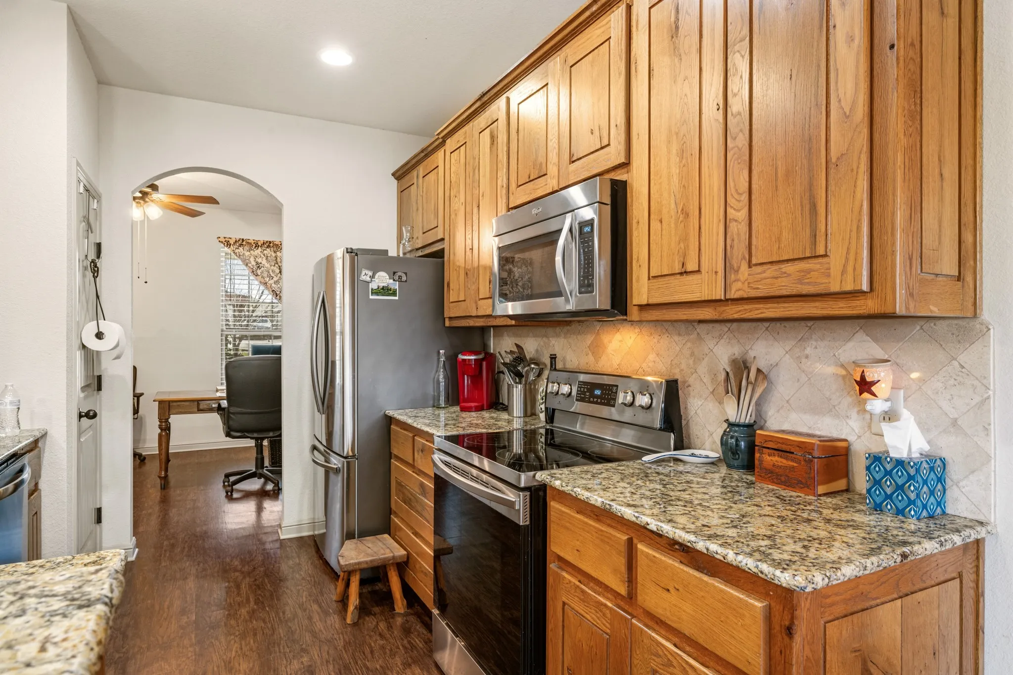 Well-appointed kitchen featuring rich wood cabinetry, granite countertops, and stainless steel appliances. Functional layout with ample storage and workspace, perfect for everyday cooking and entertaining.