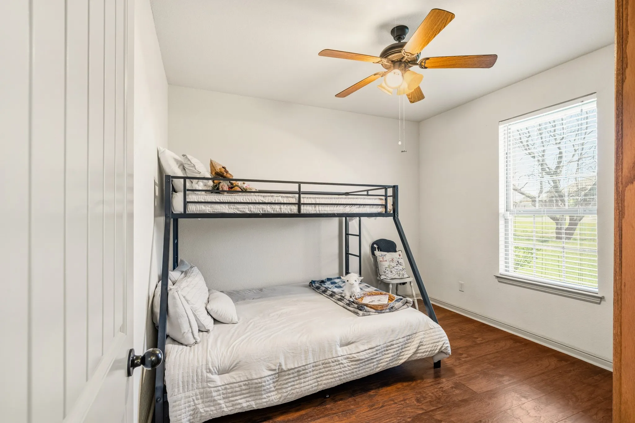 Secondary bedroom features hard surface flooring and a ceiling fan.