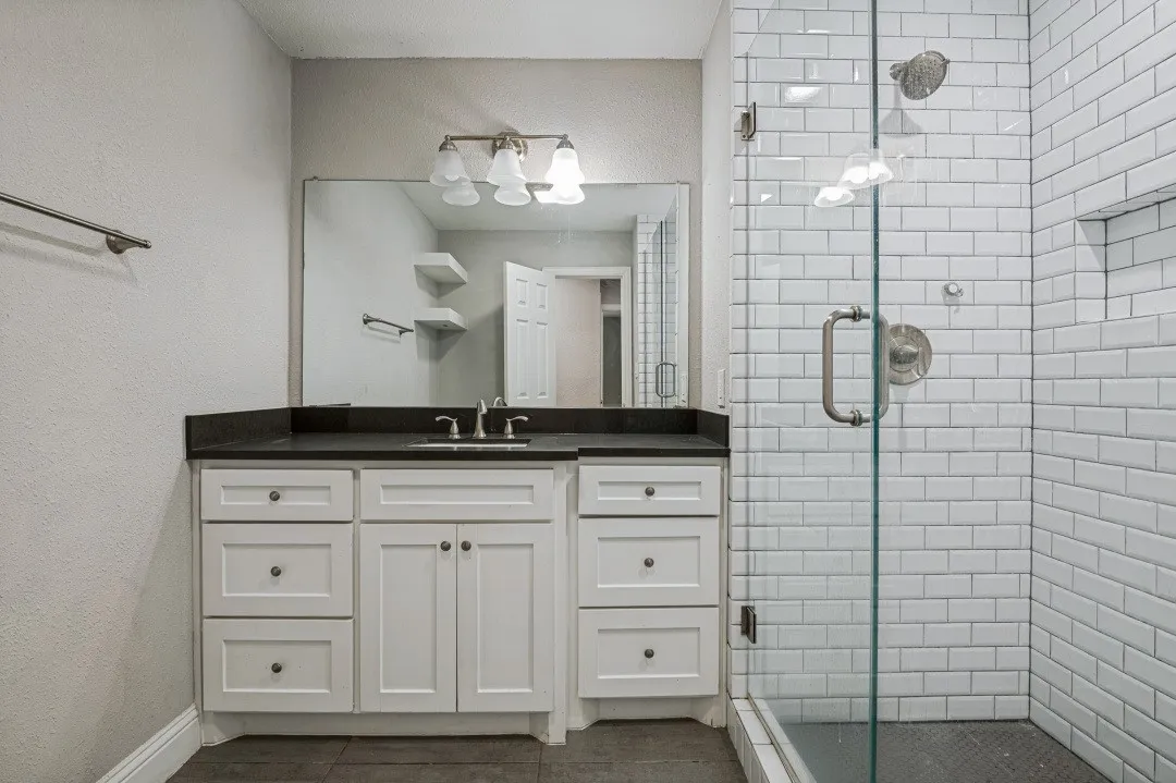 Bathroom featuring a glass-enclosed shower, white subway tile, and a built-in shower niche