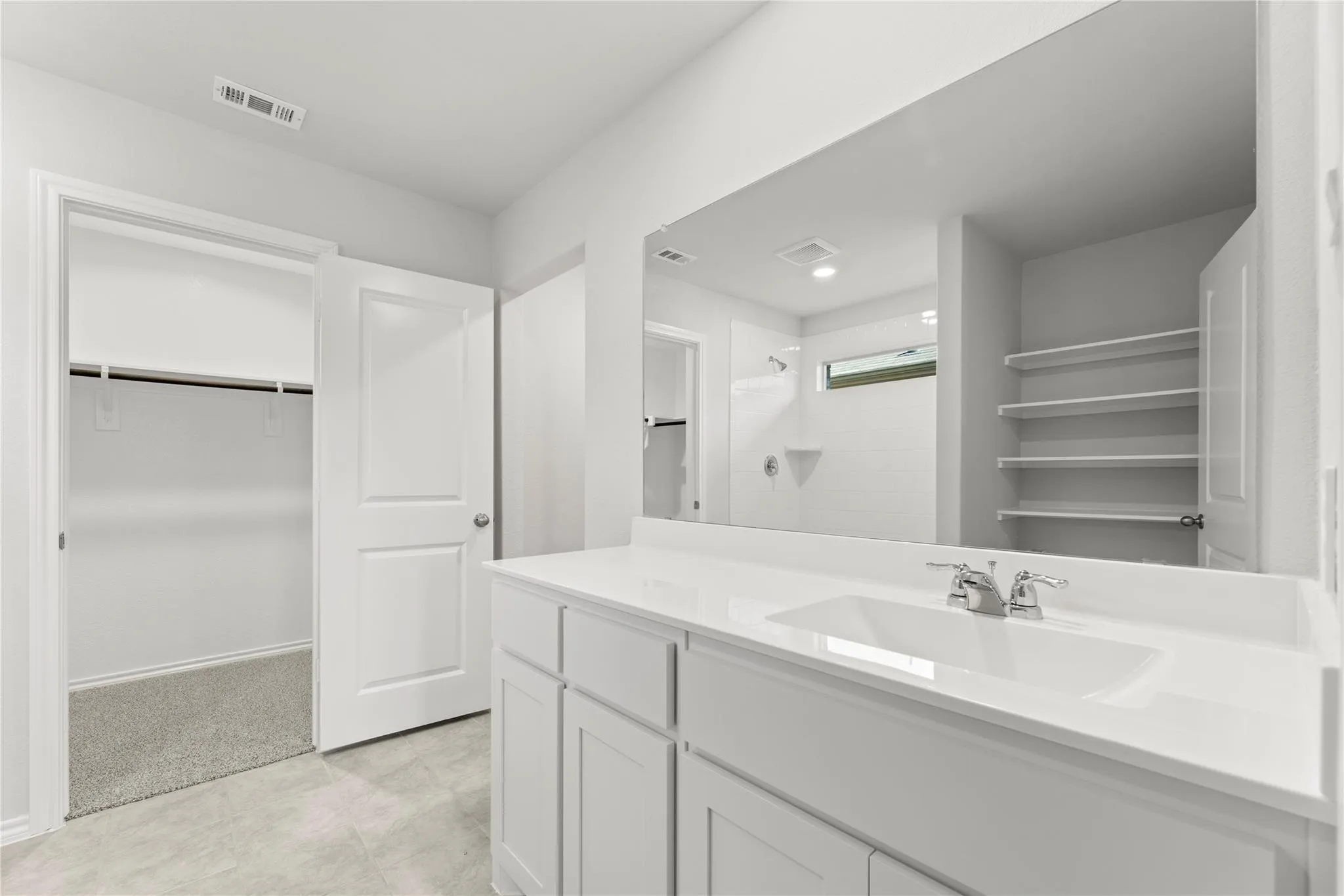Bathroom featuring a single vanity with an integrated sink, polished chrome faucet, and expansive mirror