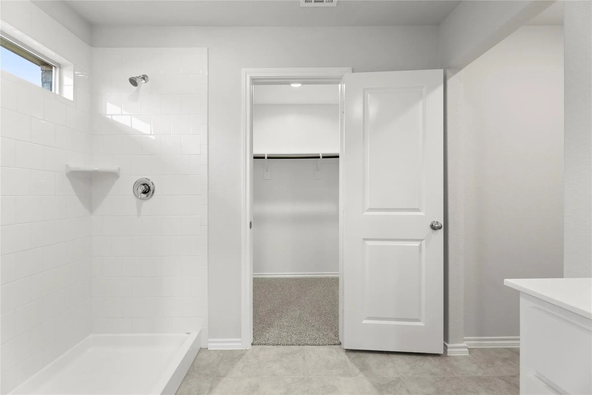 Modern bathroom featuring a white subway tile shower with a built-in corner shelf and polished chrome fixtures