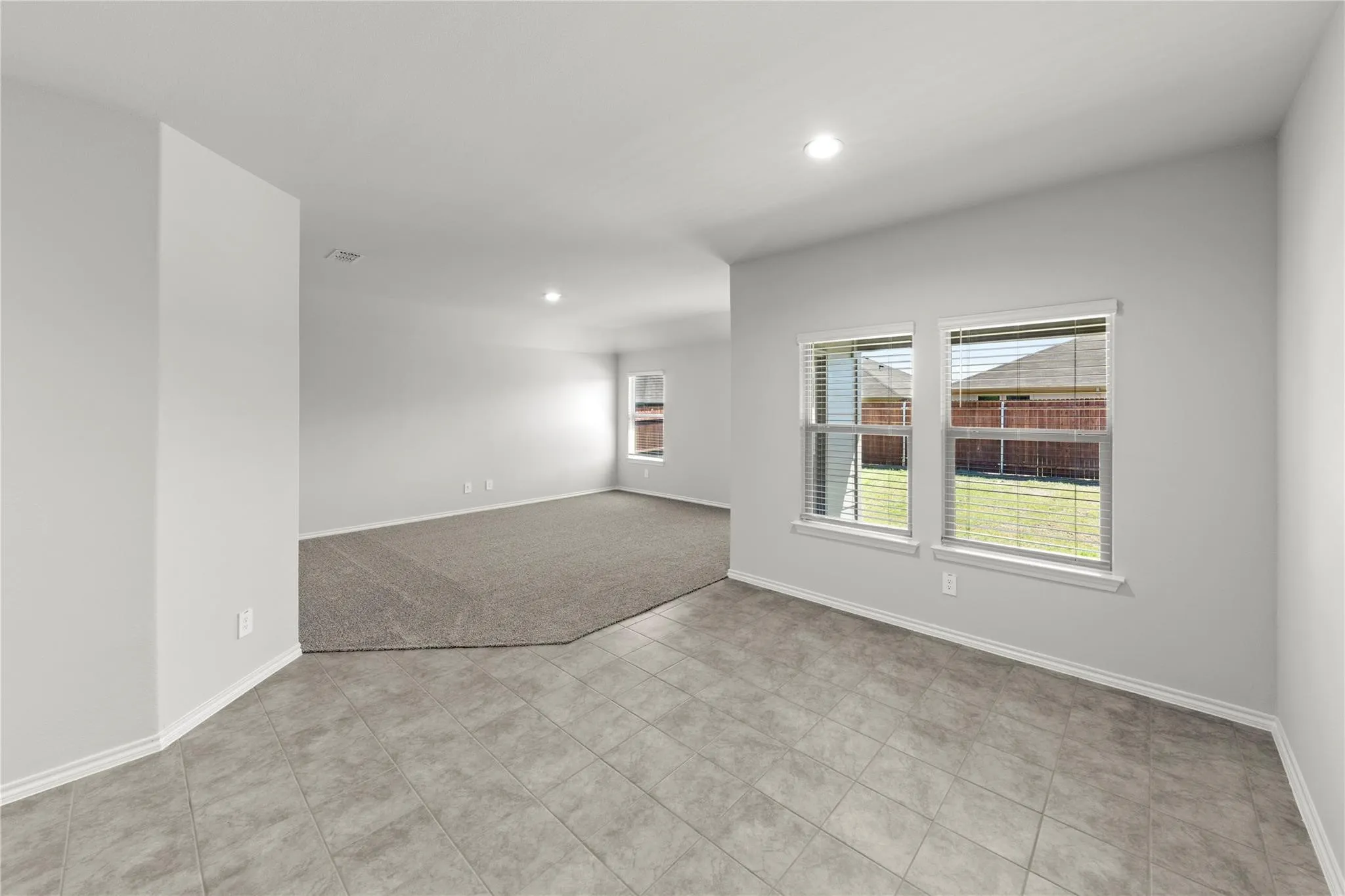 Open-concept interior featuring light gray walls, recessed lighting, and white baseboards