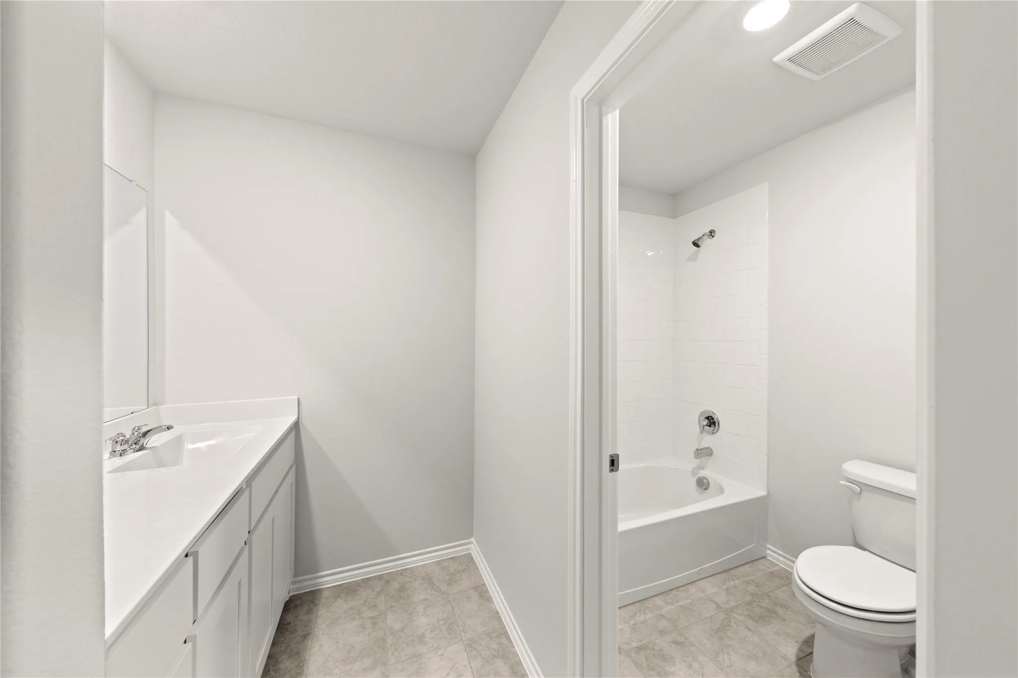 Bathroom featuring a single vanity with an undermount sink, a chrome faucet, and a large mirror