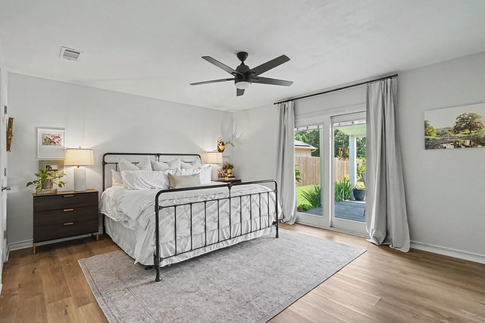 Spacious primary bedroom with two walk-in closets. Covered porch with deck off the bedroom.