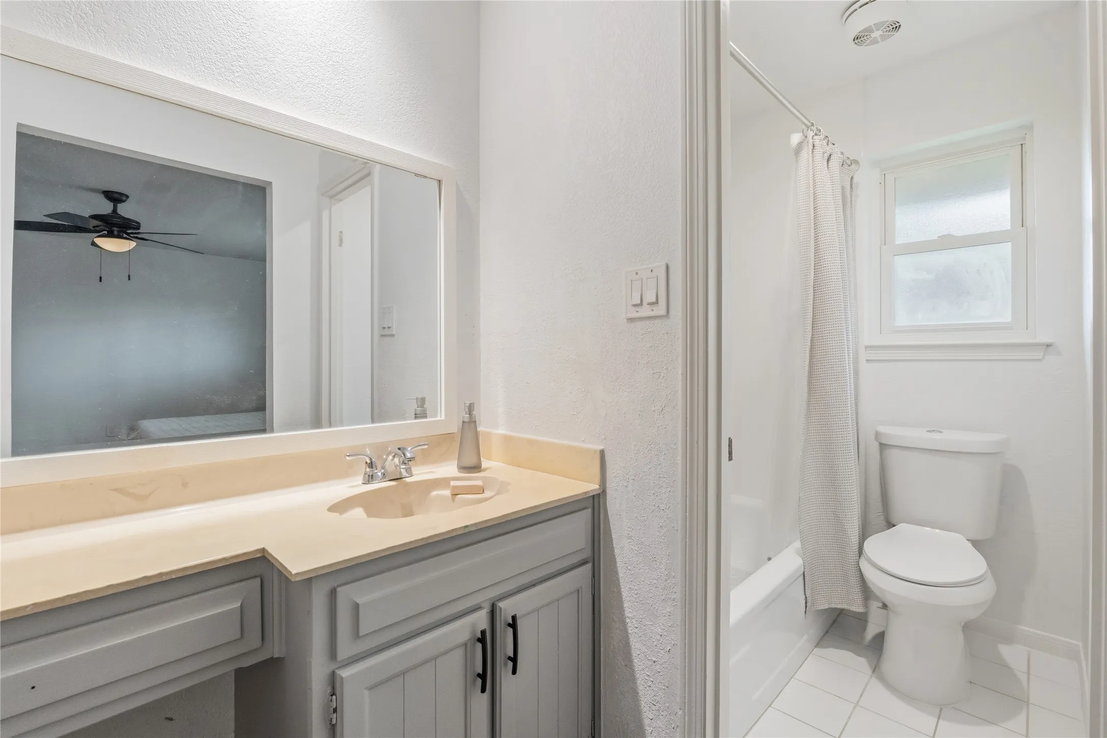 Bathroom featuring a vanity with a light-toned countertop, integrated sink, and cabinet storage