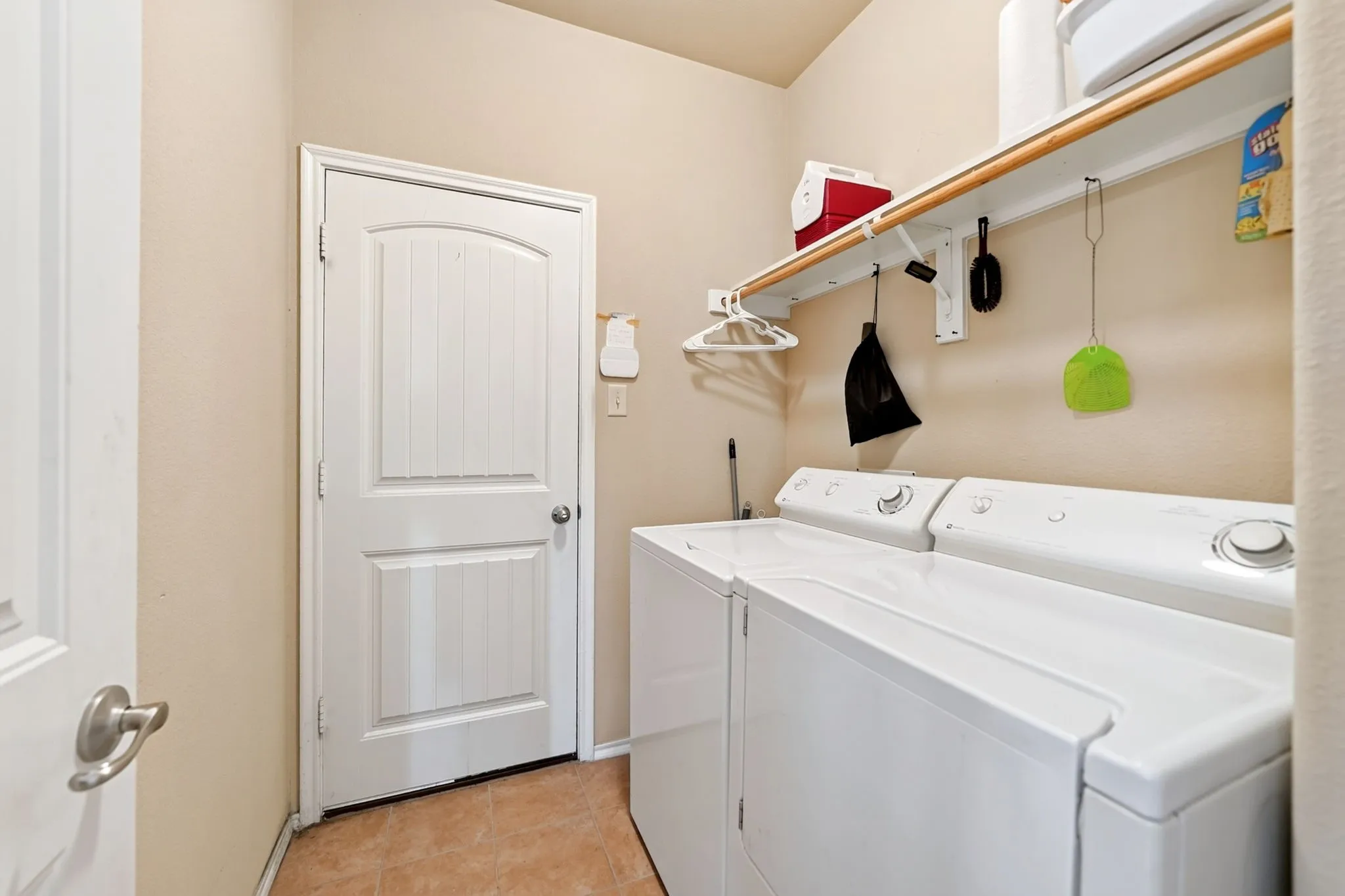 Dedicated utility space featuring tile flooring and neutral wall tones