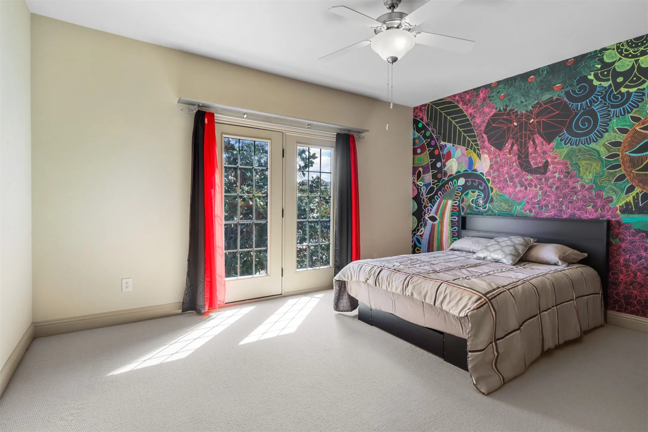 Spacious room featuring light-colored carpeting, a unique accent wall, and a ceiling fan with integrated lighting