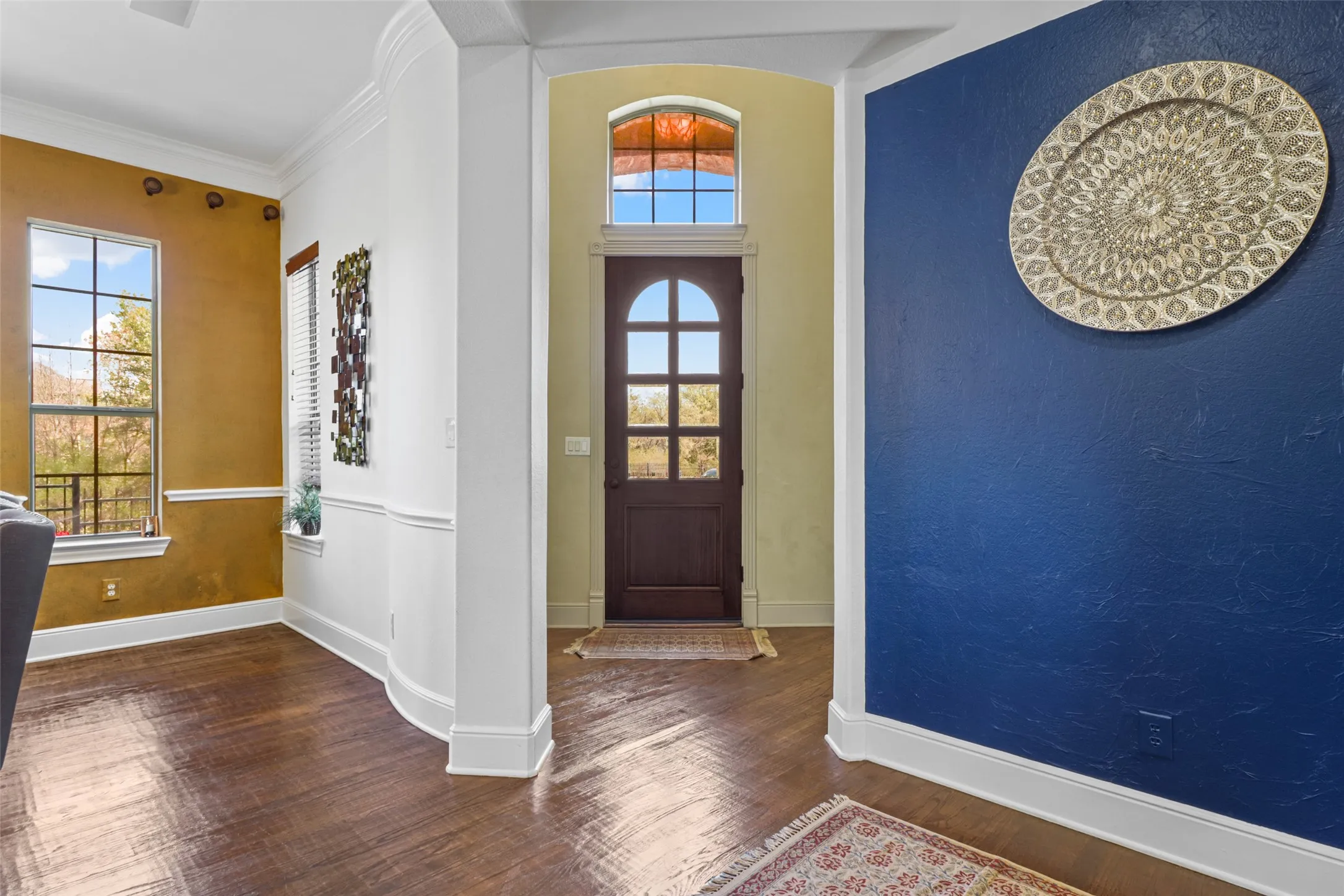 Arched entryway featuring a dark wood door with glass paneling and an arched transom window
