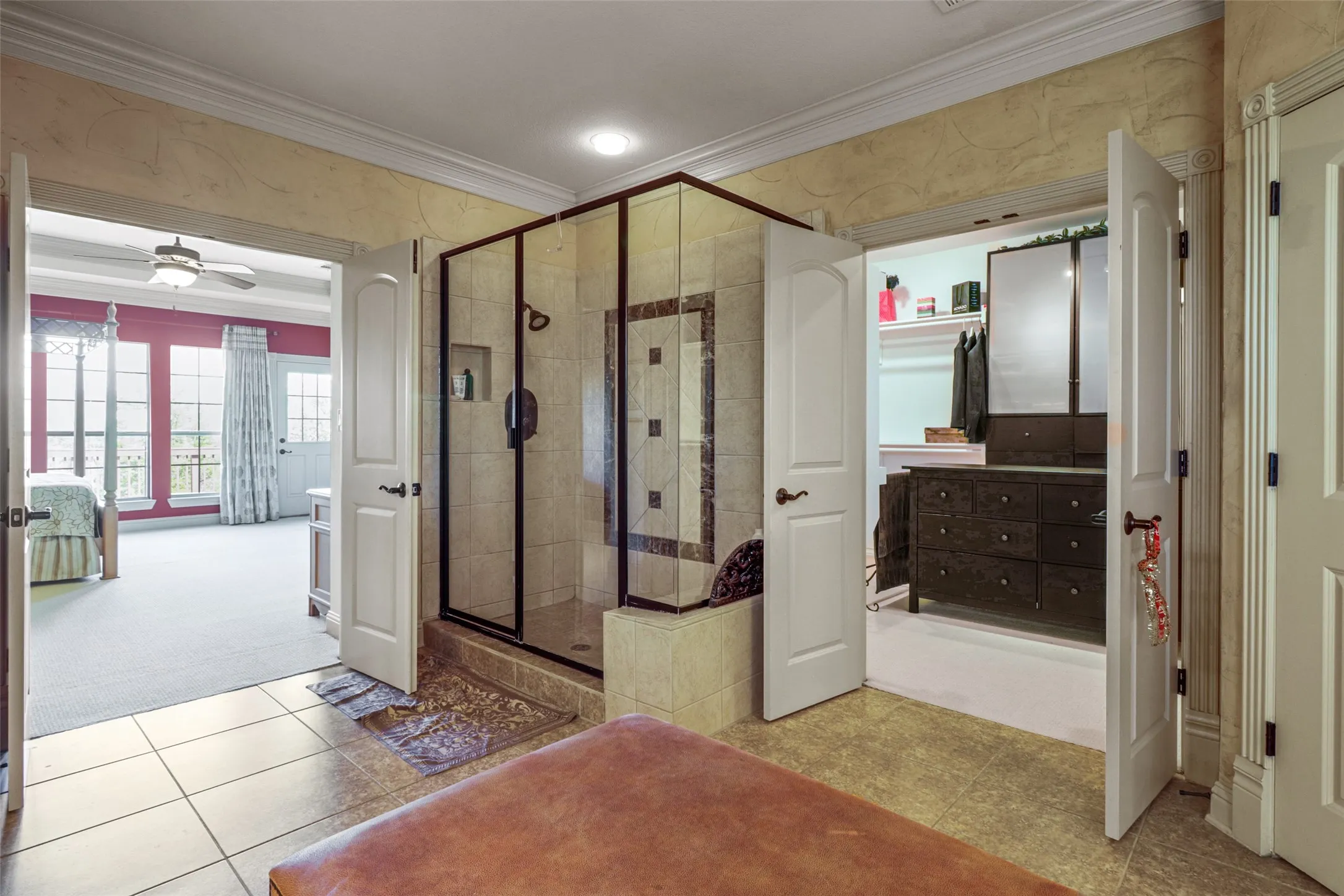 Glass-enclosed shower with tile surround and integrated shelving, featuring a decorative tile inlay