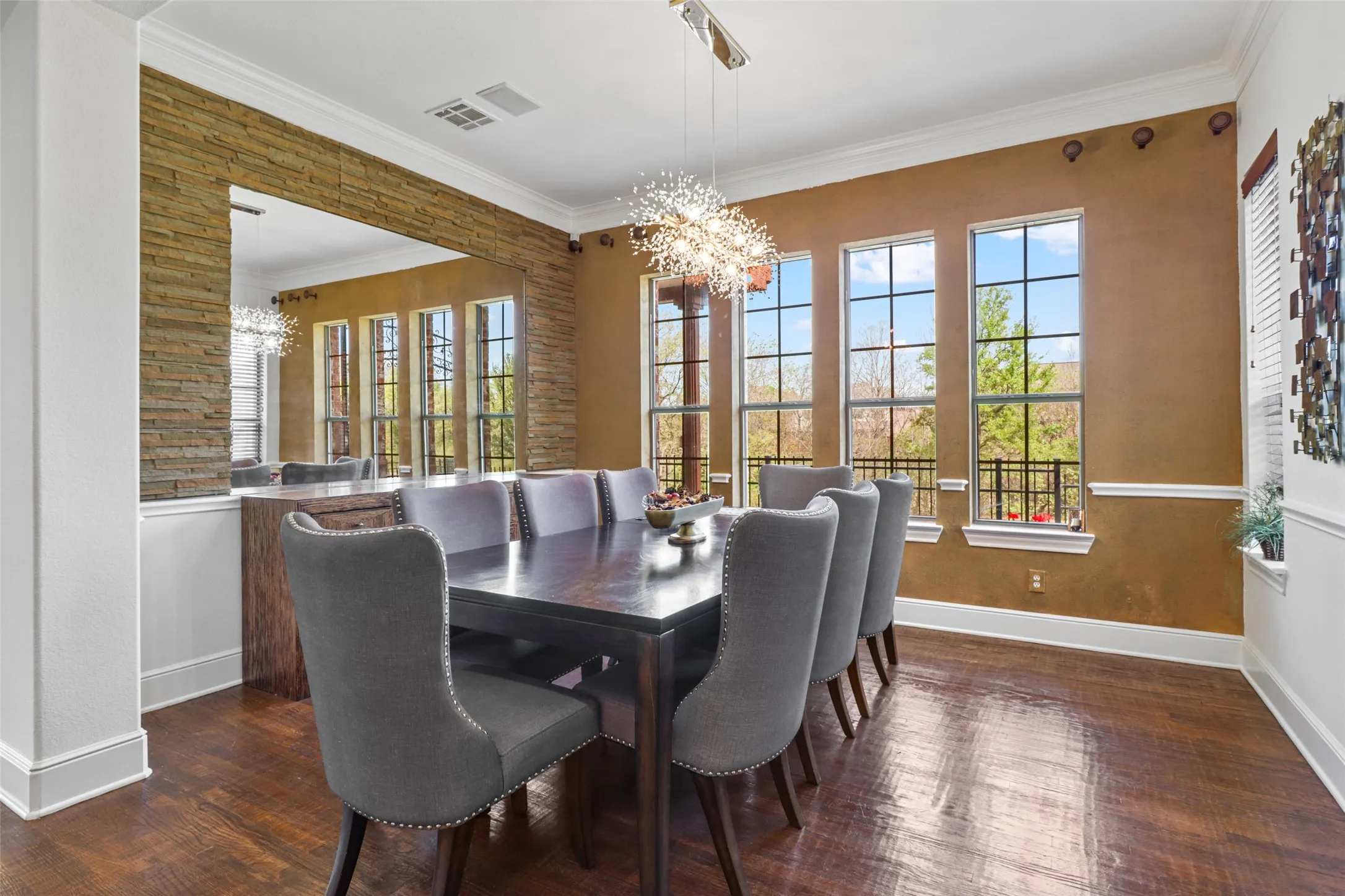 Formal dining space featuring wood-finish flooring, a contemporary chandelier, and multiple tall windows
