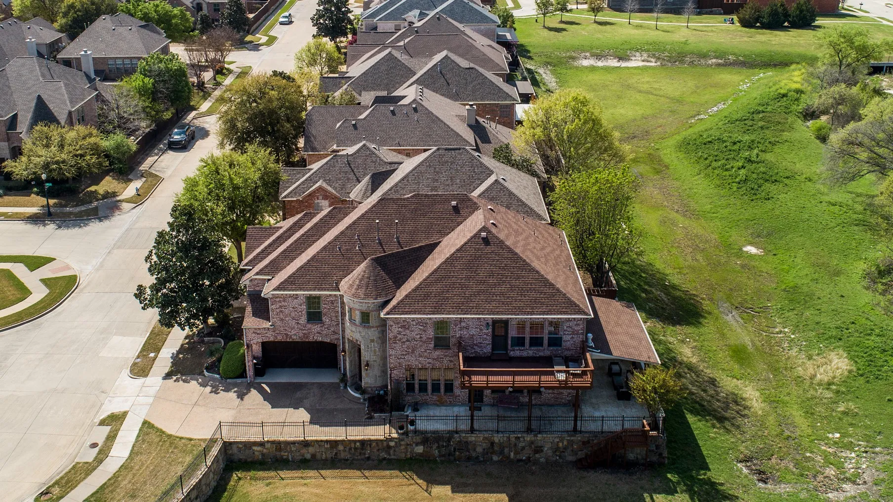Two-story brick and stone residence featuring a multi-level deck and an attached garage