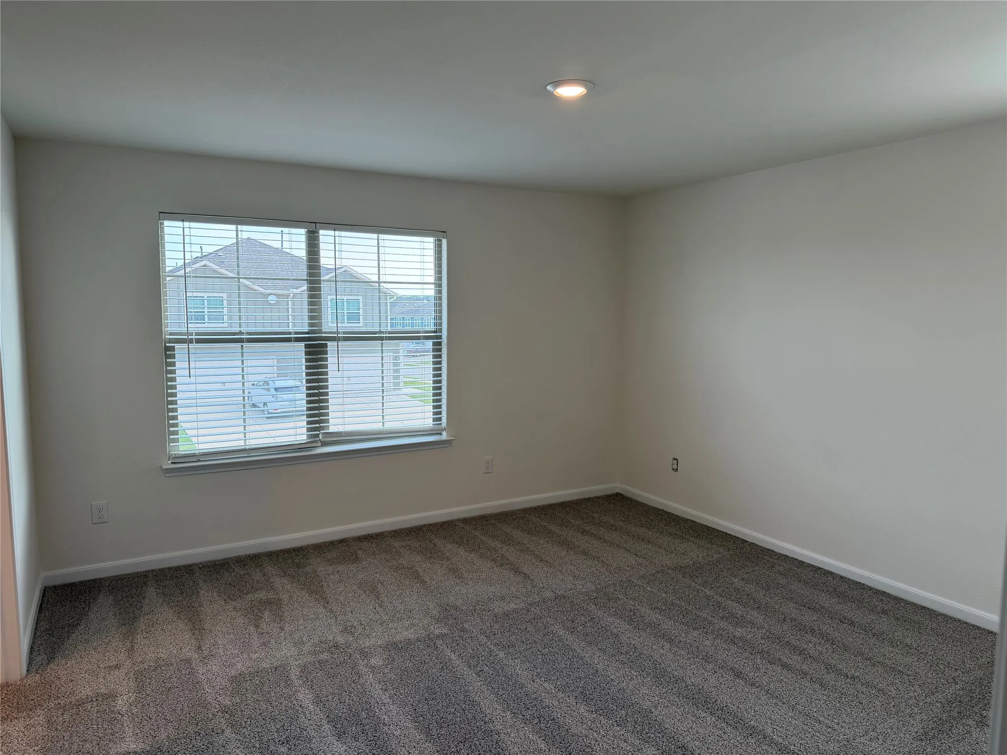 Neutral-toned interior featuring plush gray carpeting and a recessed ceiling light
