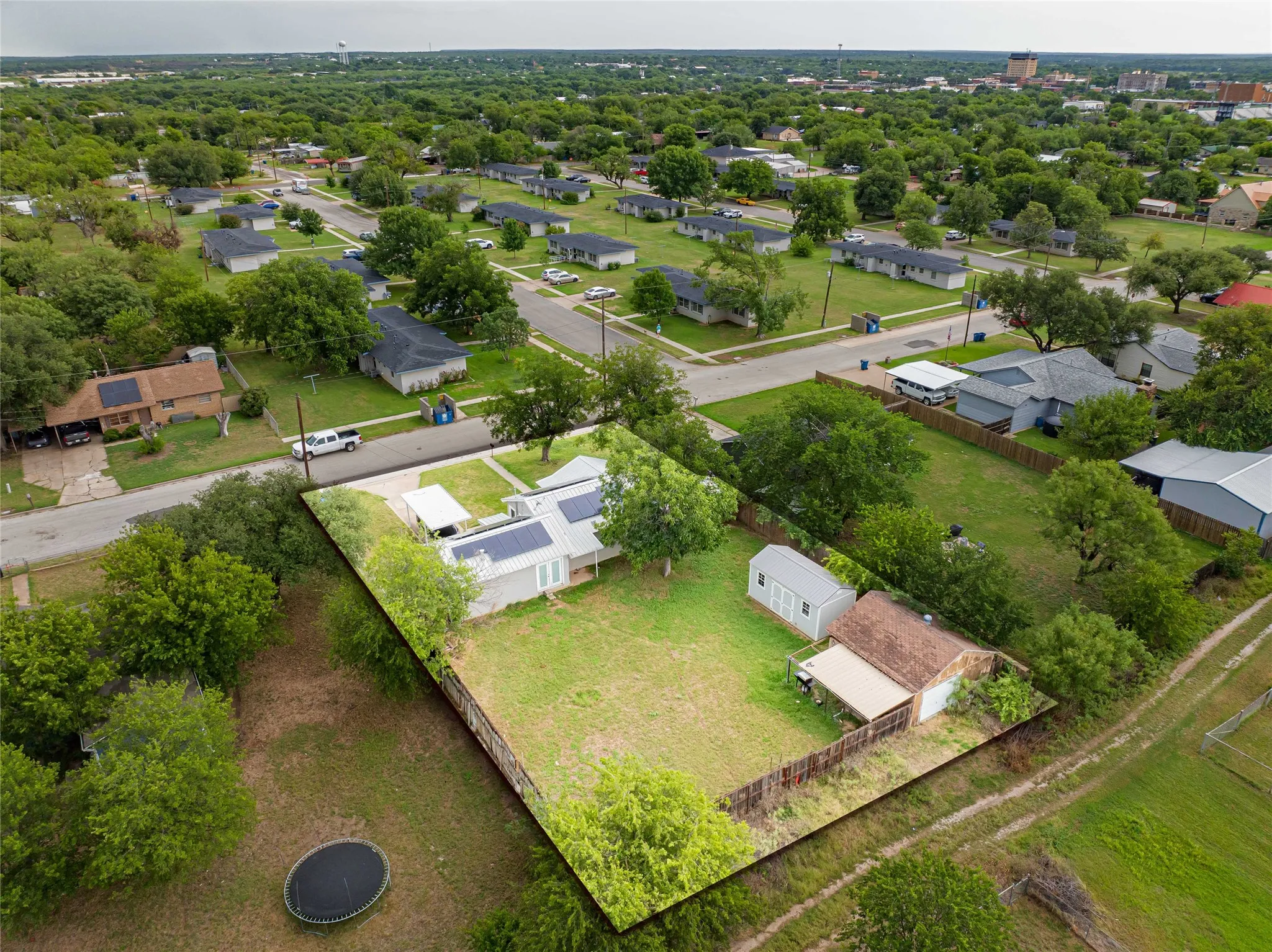 Expansive property featuring a fenced backyard, detached storage shed, and mature trees
