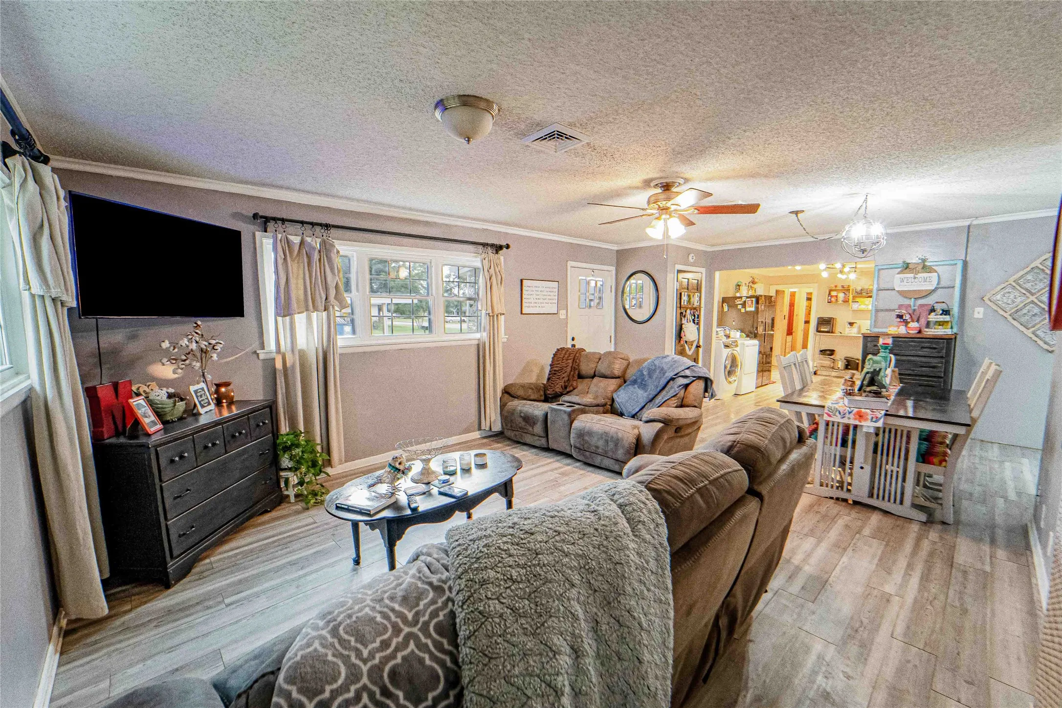 Open-concept living area featuring wood-finish flooring, recessed lighting, and a ceiling fan