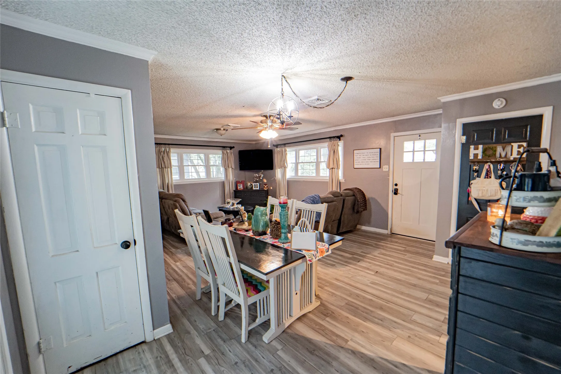 Open-concept living space with light-finish flooring and grey wall tones