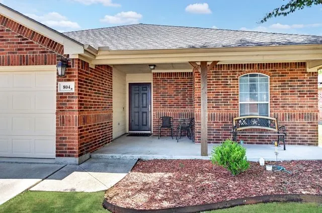 Brick exterior featuring a covered front porch with a wood column