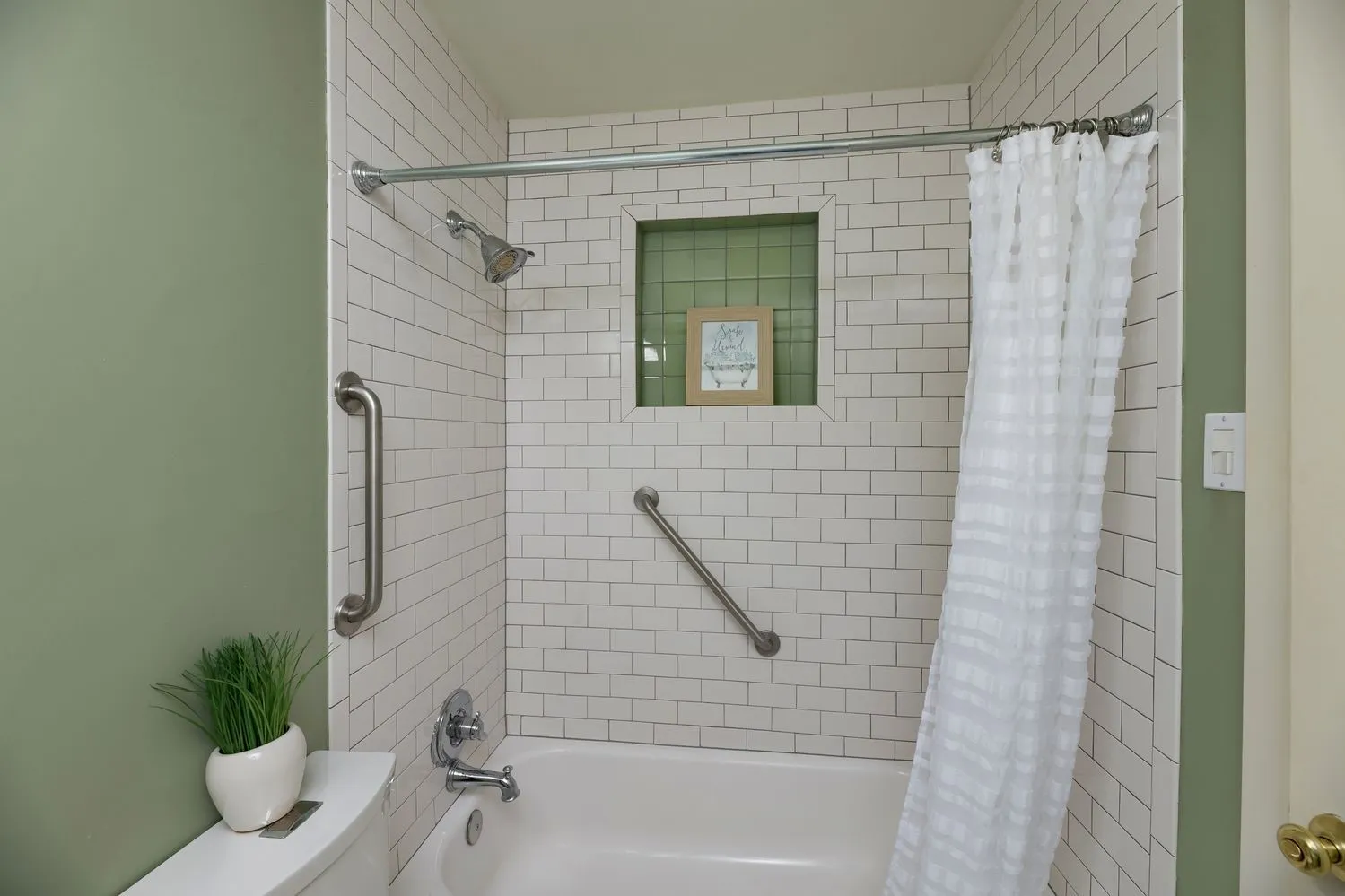 Bathtub with subway tile surround and integrated shower niche