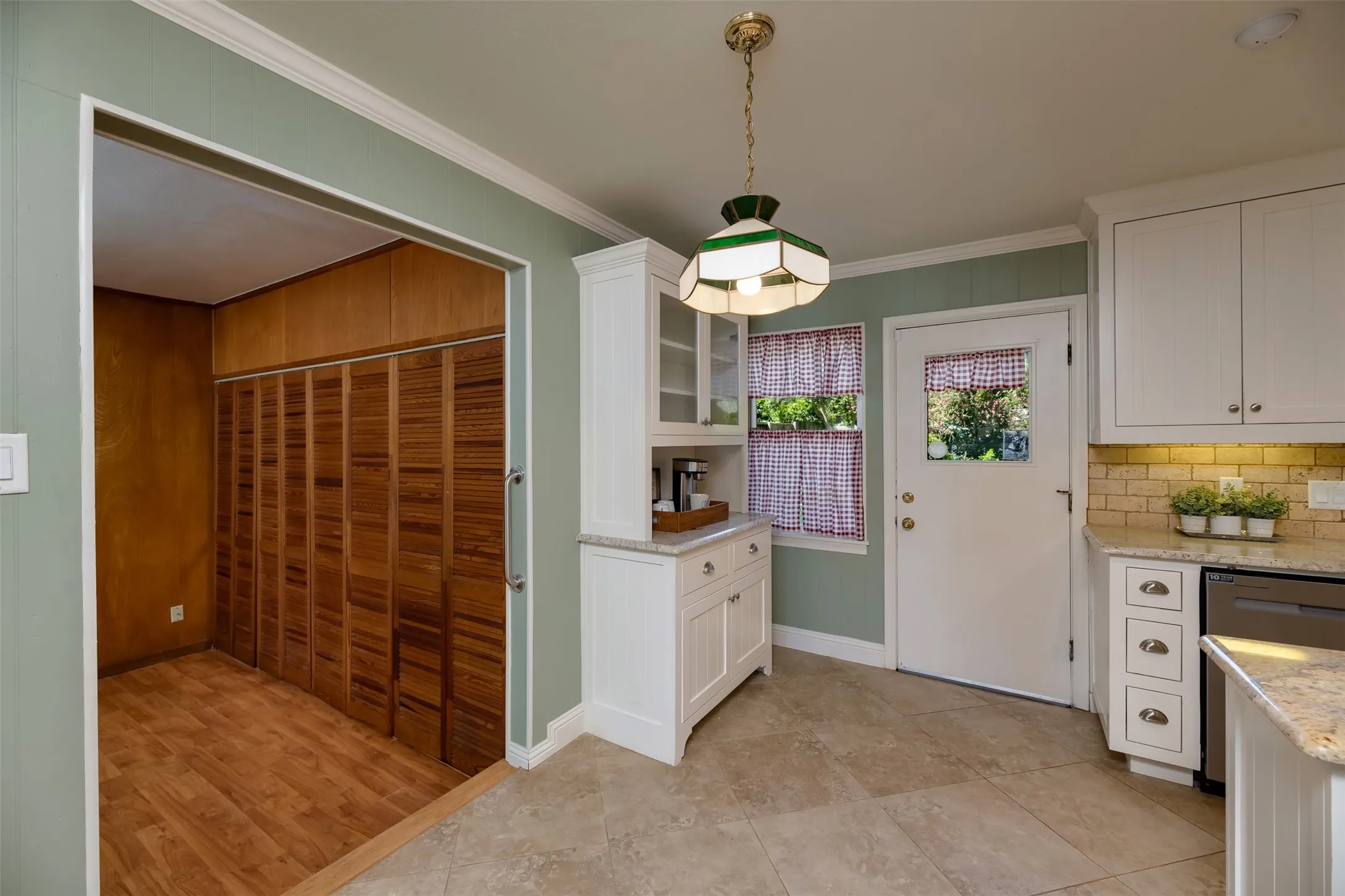 Kitchen featuring white cabinetry, granite countertops, subway tile backsplash, and tile flooring