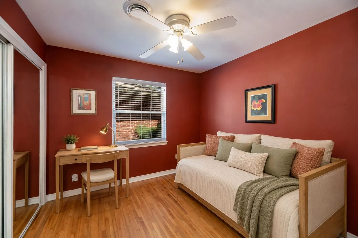Virtually Staged - Warm-toned interior room featuring wood-finish flooring, a window with horizontal blinds, and a ceiling fan