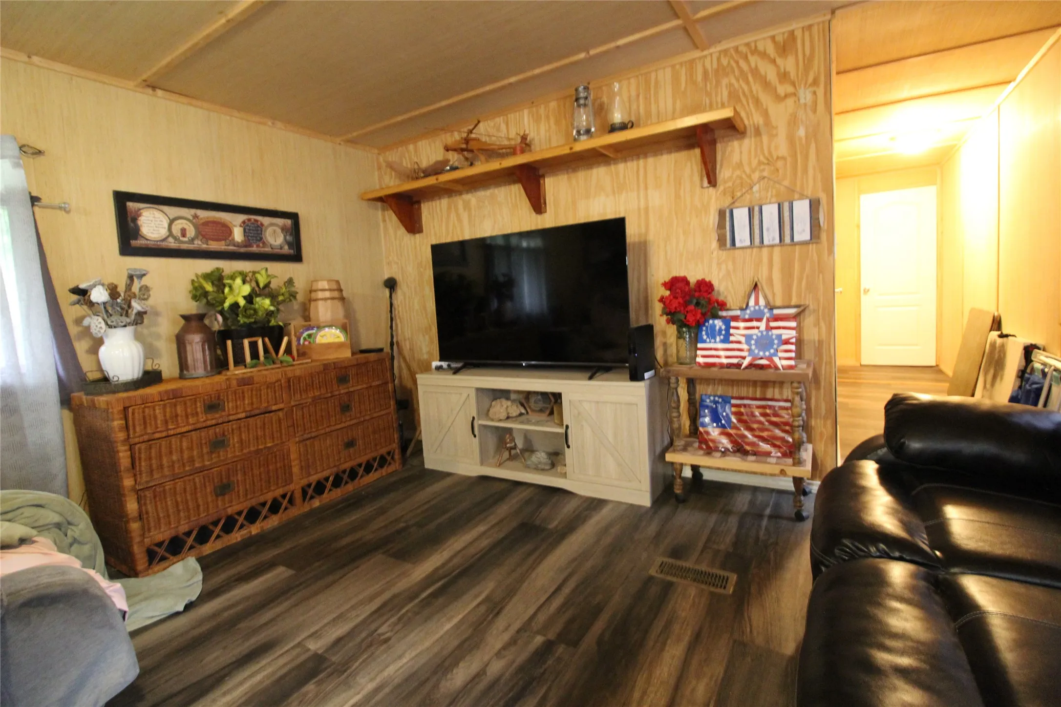 Interior space featuring wood-finish flooring, wood paneling, and a built-in shelf