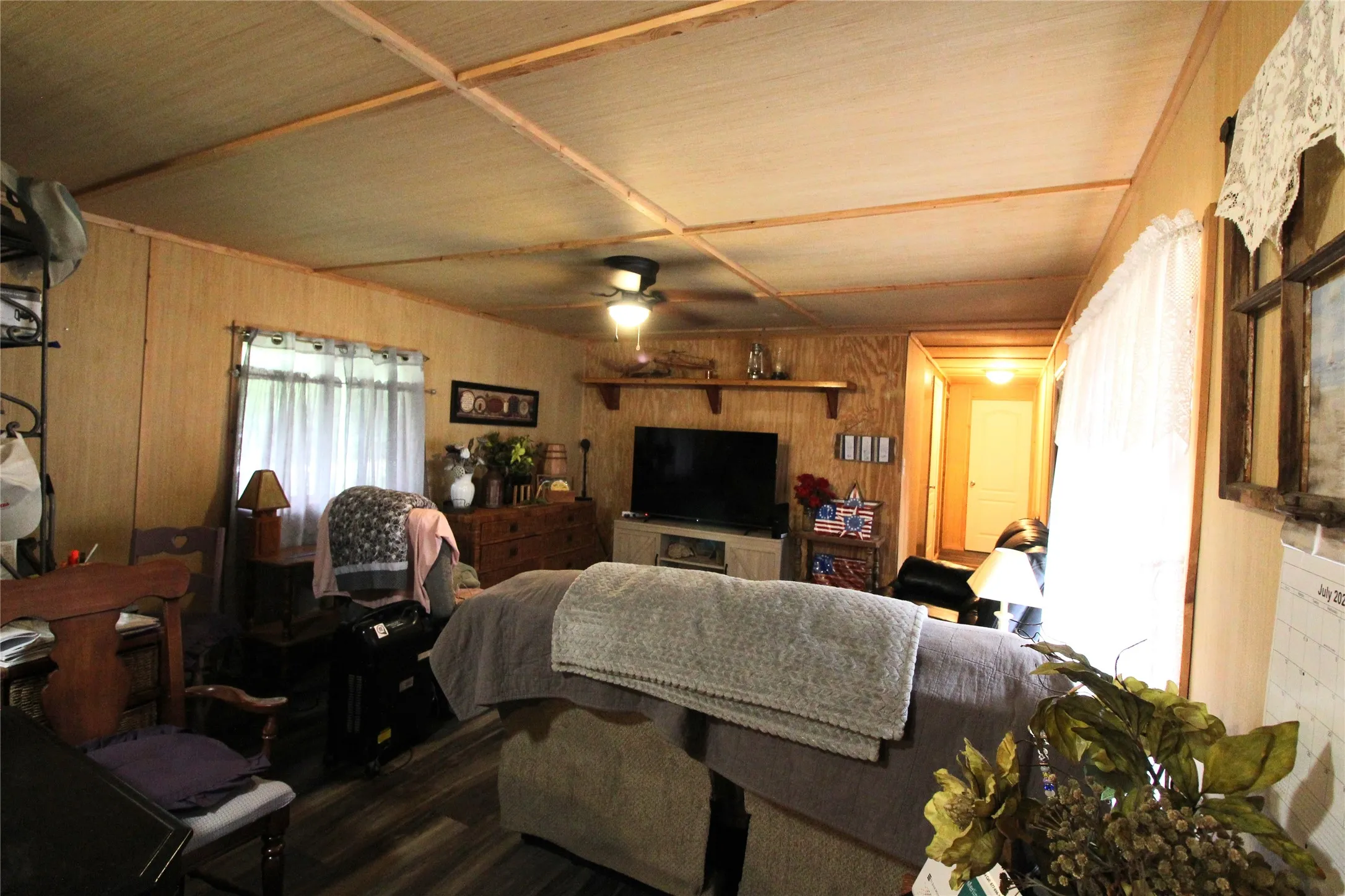 Living area featuring wood-finish walls and complementary wood-finish flooring