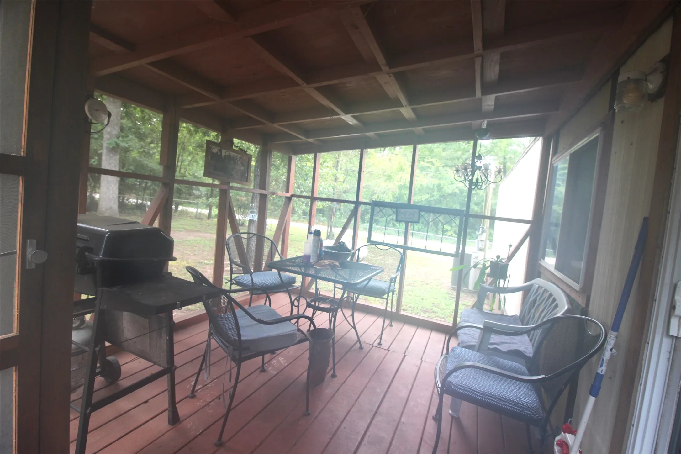 Screened-in porch featuring a wood-finish floor and exposed beam ceiling