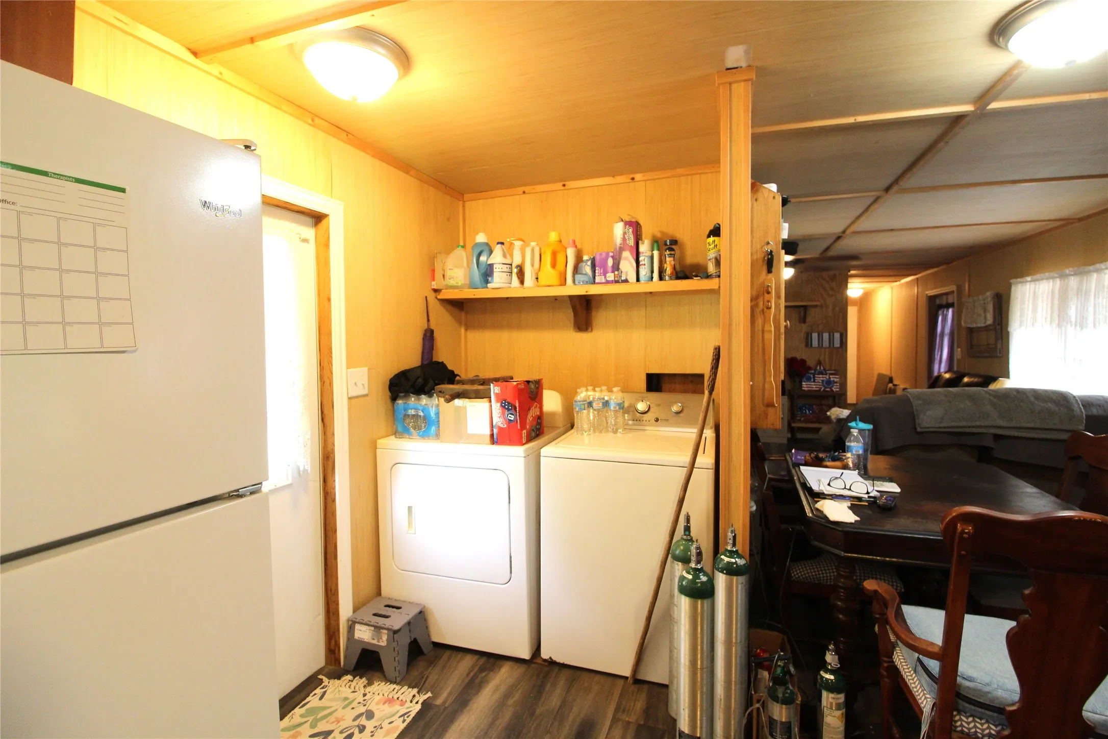 Utility area with wood-finish flooring, paneled walls, and a built-in shelving unit