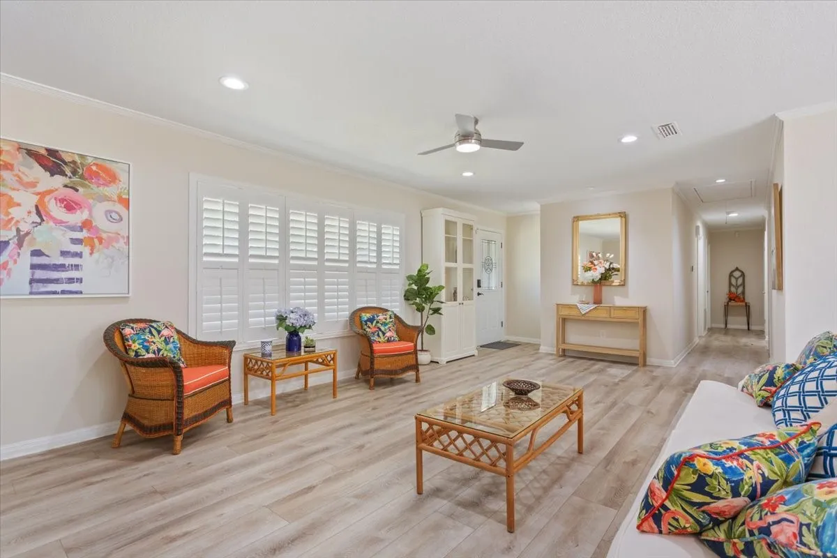 Wood-finish flooring throughout, white plantation shutters, recessed lighting, and a ceiling fan