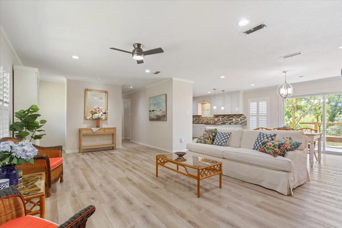 Open-concept living area featuring wood-finish flooring, recessed lighting, and a ceiling fan