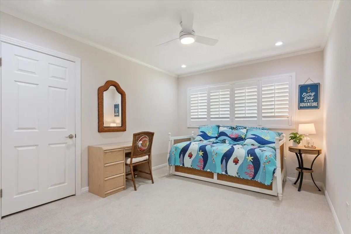 Recessed lighting, ceiling fan, crown molding, white plantation shutters, and carpet flooring