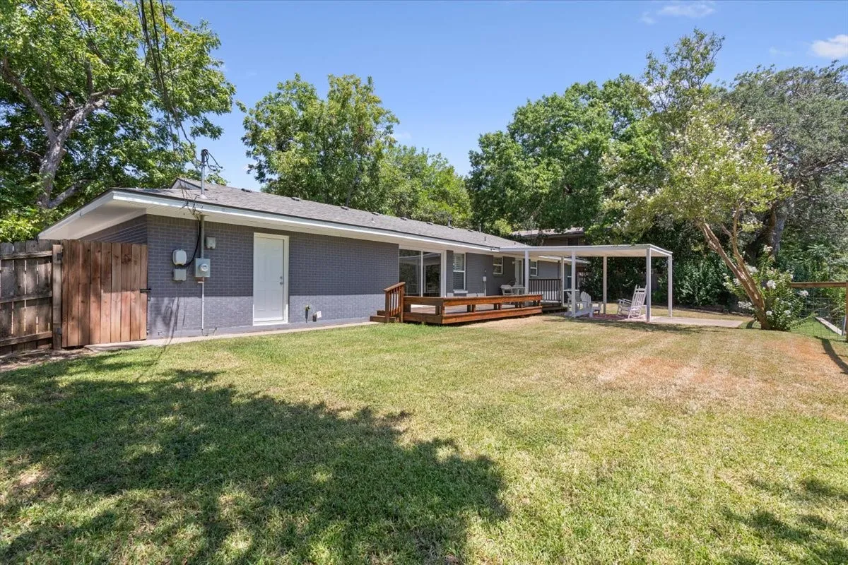 Expansive backyard featuring a wood deck, covered patio, and privacy fencing