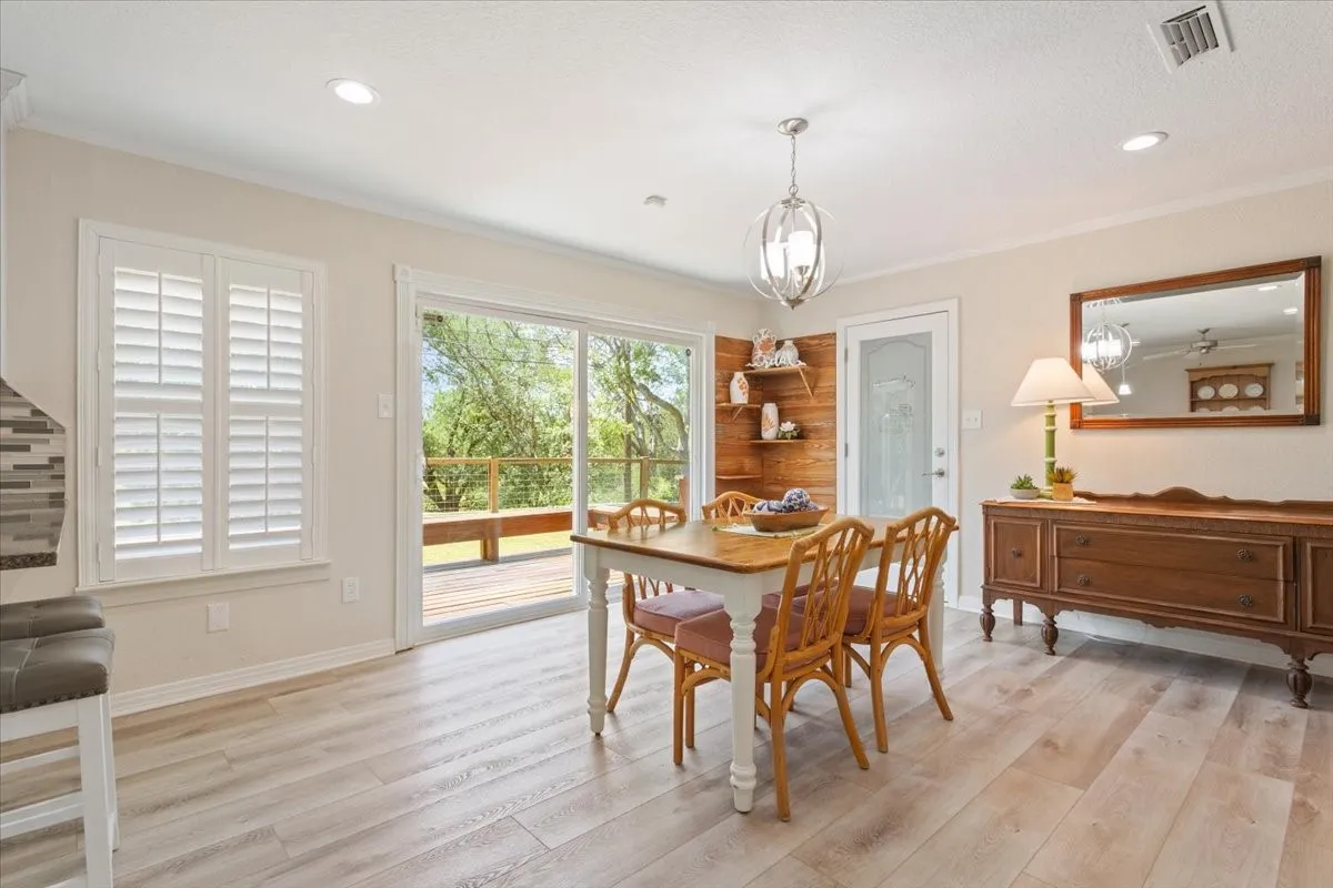 Light wood-finish flooring, recessed lighting, and a sliding glass door to an exterior deck