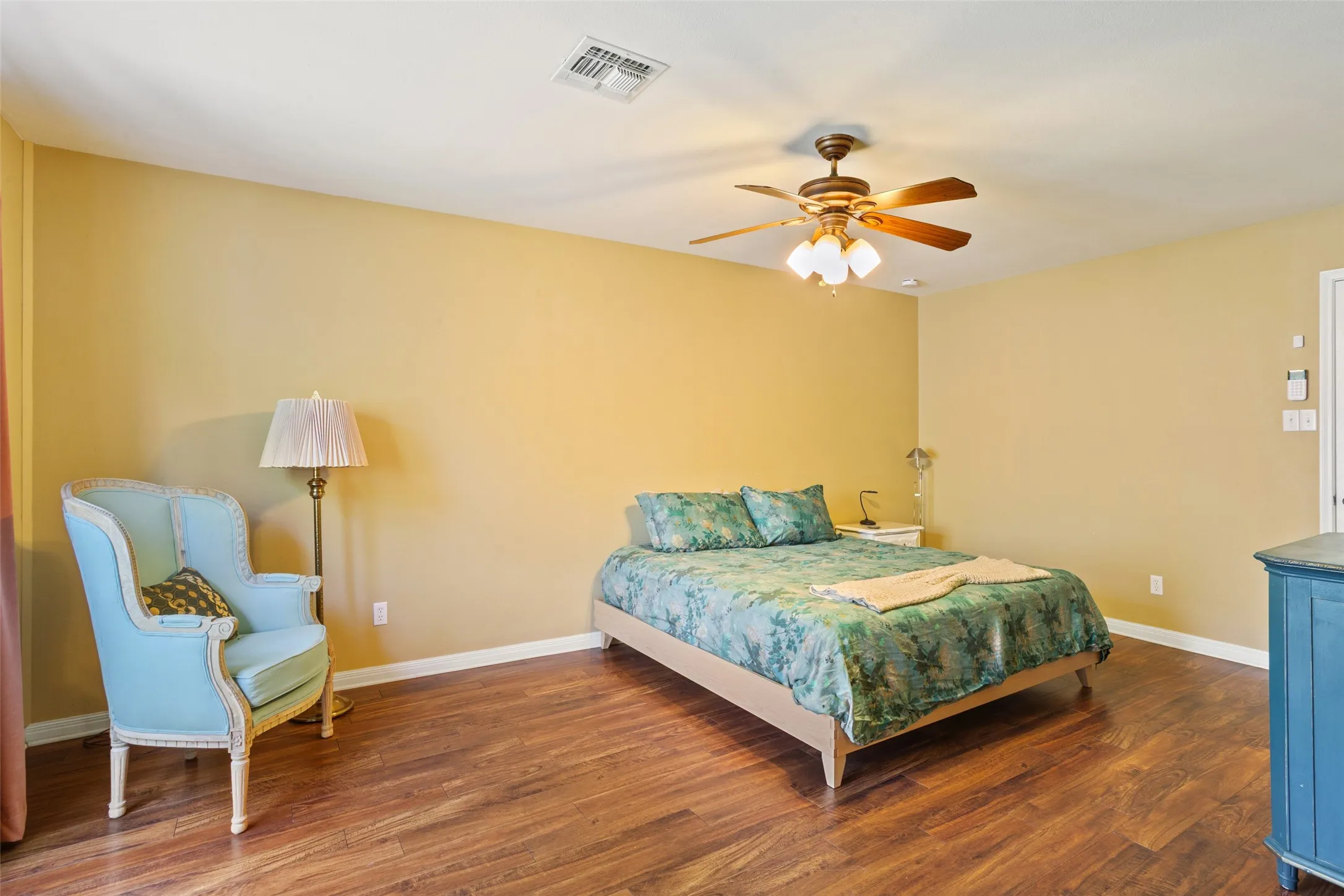 Wood-finish flooring, ceiling fan with integrated lighting, recessed lighting, and light-toned walls