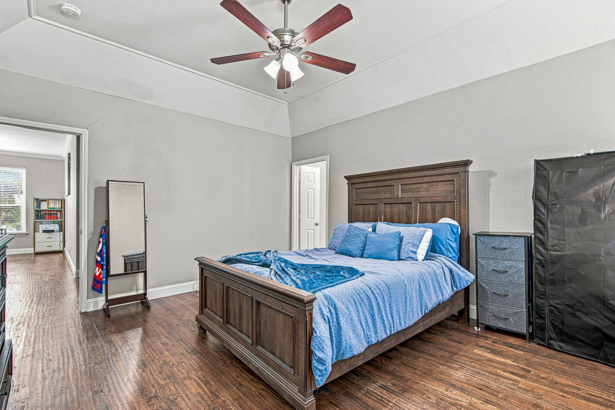 Wood-finish flooring, recessed ceiling, ceiling fan, and painted walls