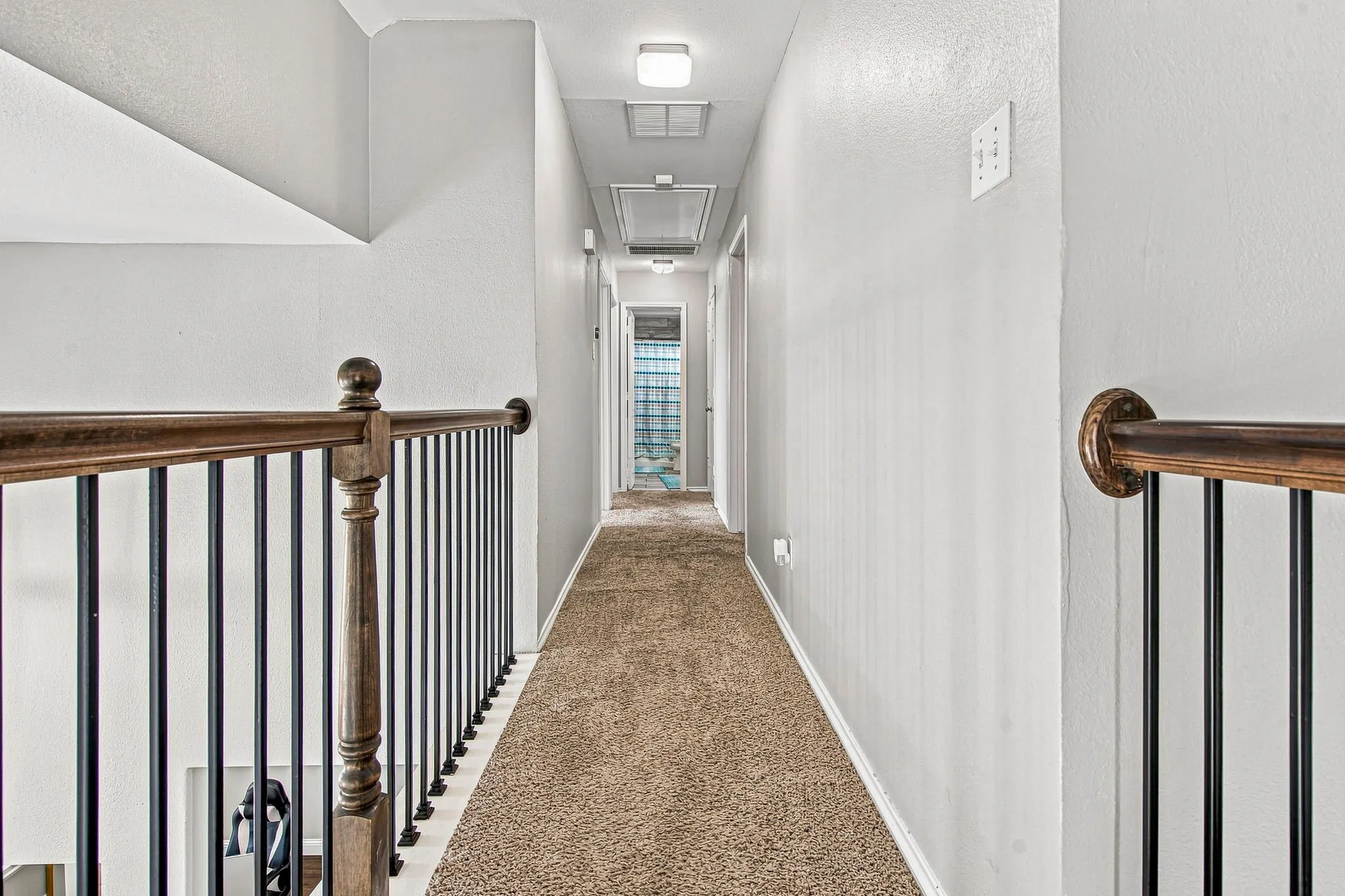 Hallway with textured walls, recessed lighting, and carpet flooring