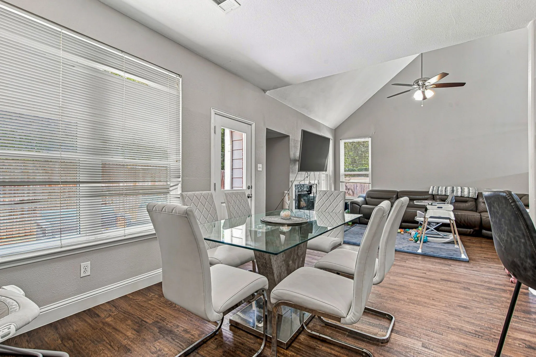 Wood-finish flooring throughout, vaulted ceiling, ceiling fan, and white trim