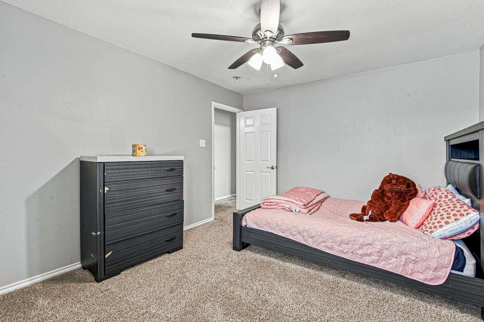 Recessed ceiling fan with integrated lighting, neutral wall tones, textured carpeting, and a white interior door
