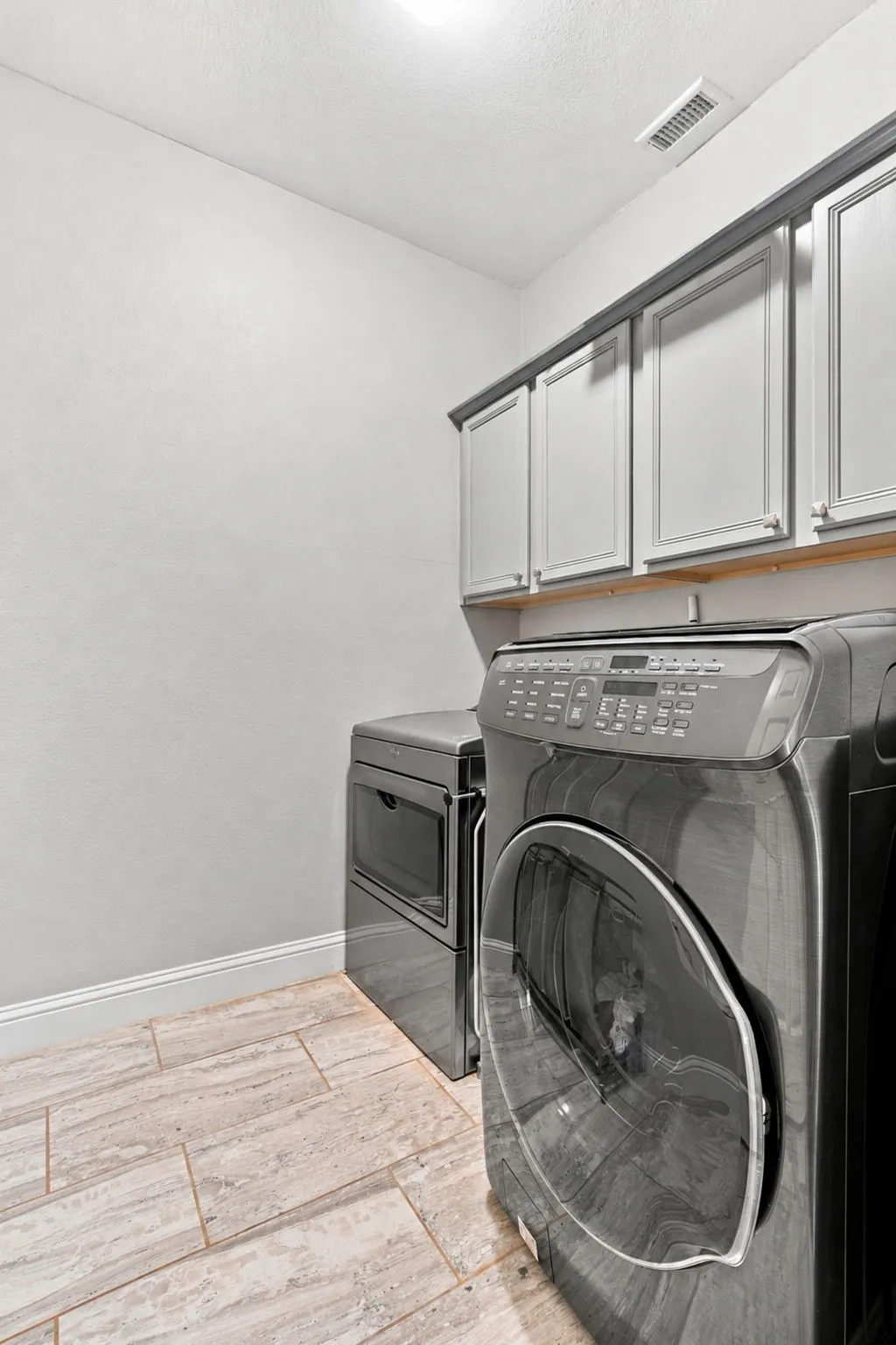 Upper cabinetry with decorative molding and under-cabinet shelving over a tiled floor