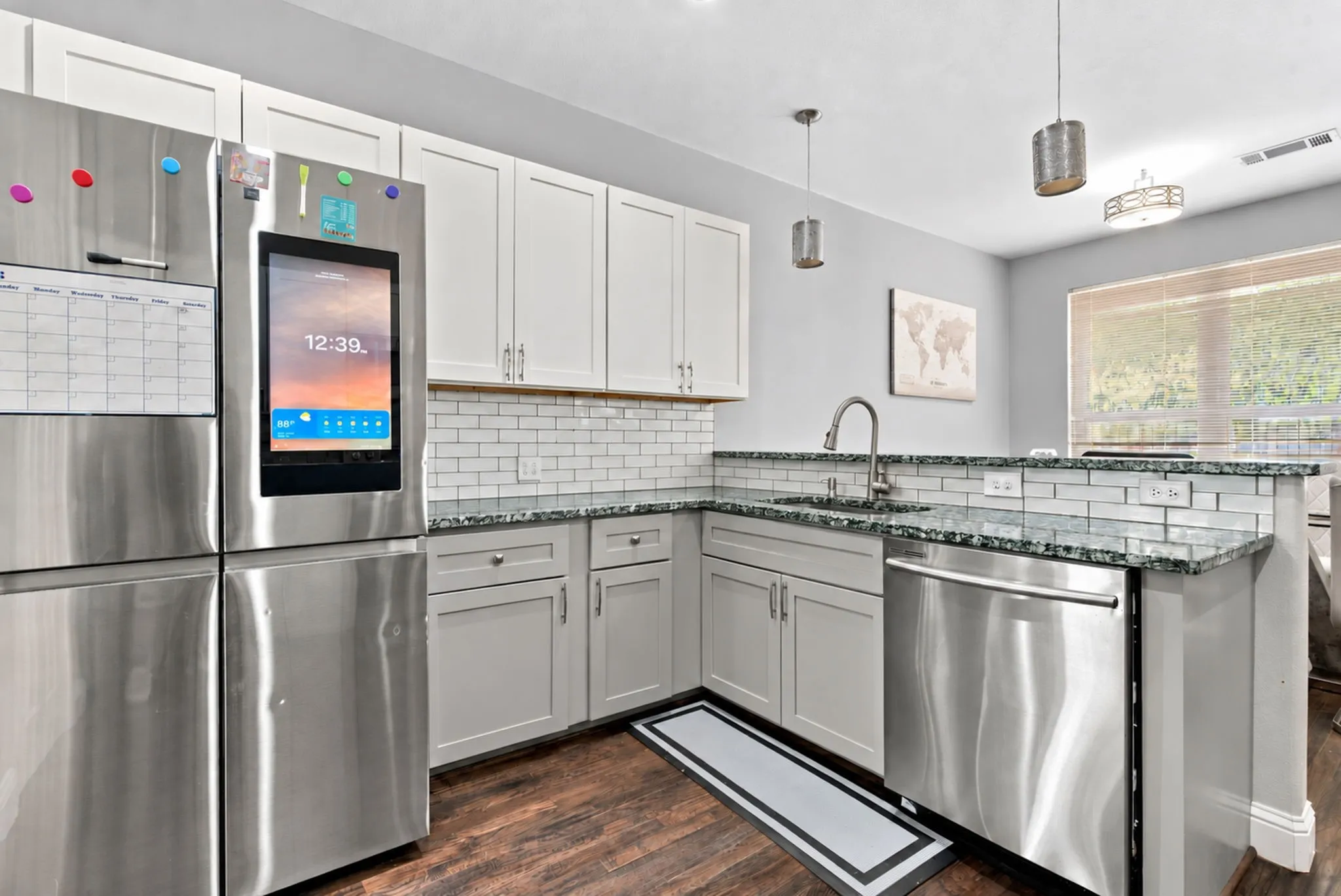 Kitchen featuring stainless steel appliances, white subway tile backsplash, light grey cabinetry, and dark wood-finish flooring