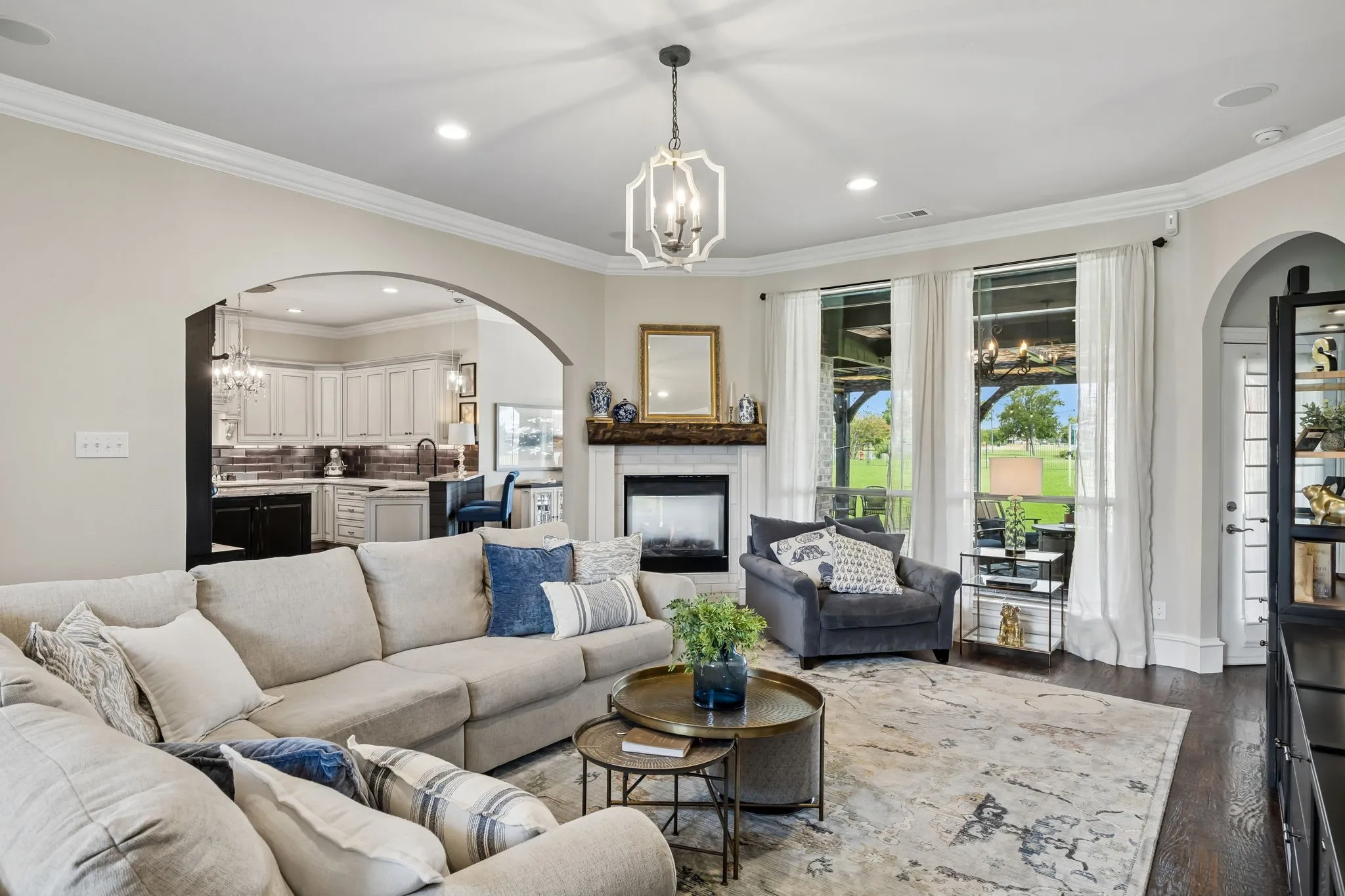 Living area featuring dark wood-finish flooring, recessed lighting, and an arched doorway