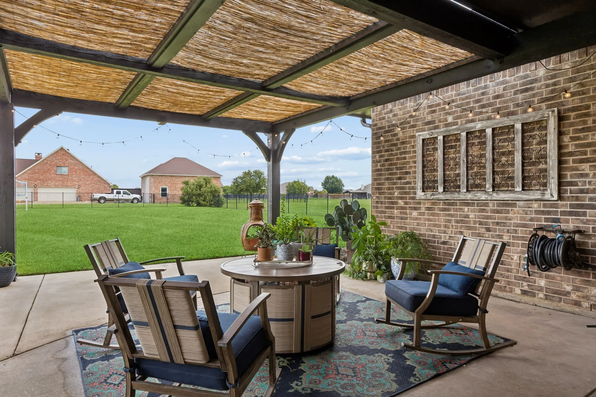 Looking into the yard from the expansive covered patio featuring a wood-frame and reed-panel roof