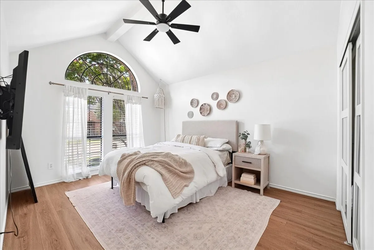 Vaulted ceilings featuring a black ceiling fan with integrated lighting