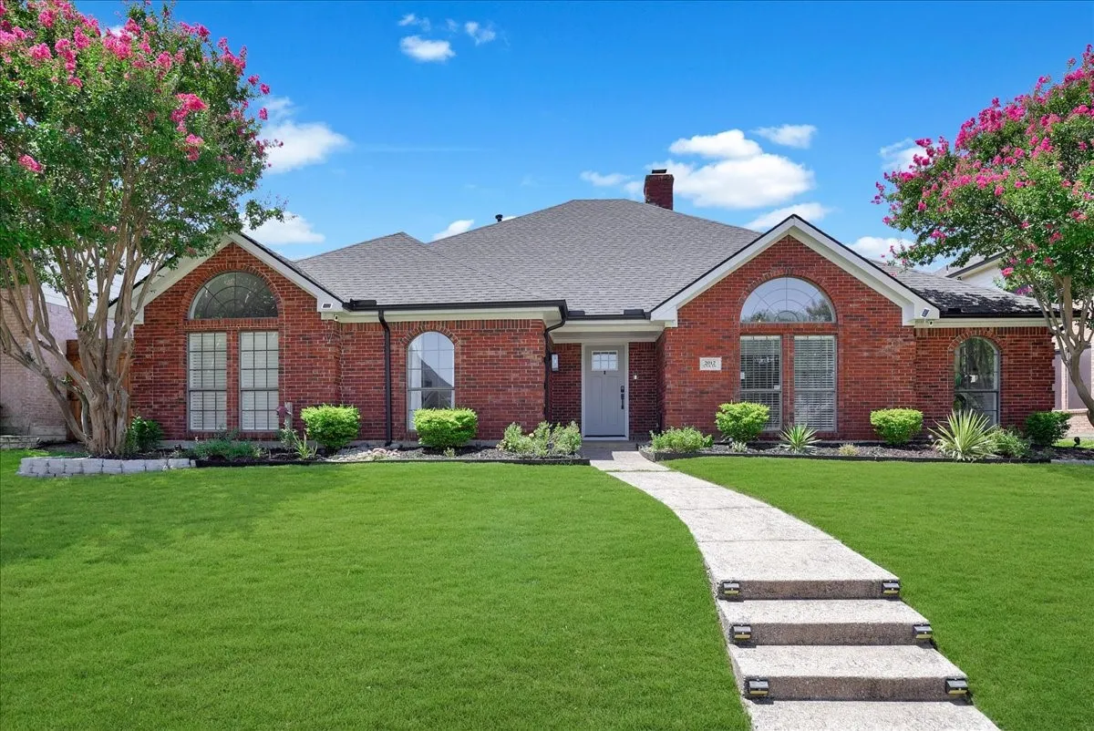 Brick exterior with a dark shingle roof and chimney