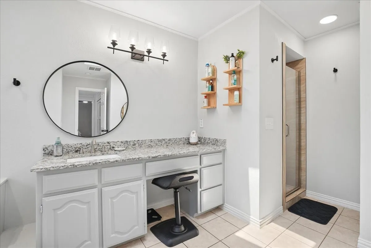 Bathroom vanity with granite countertop, integrated sink, and white cabinetry