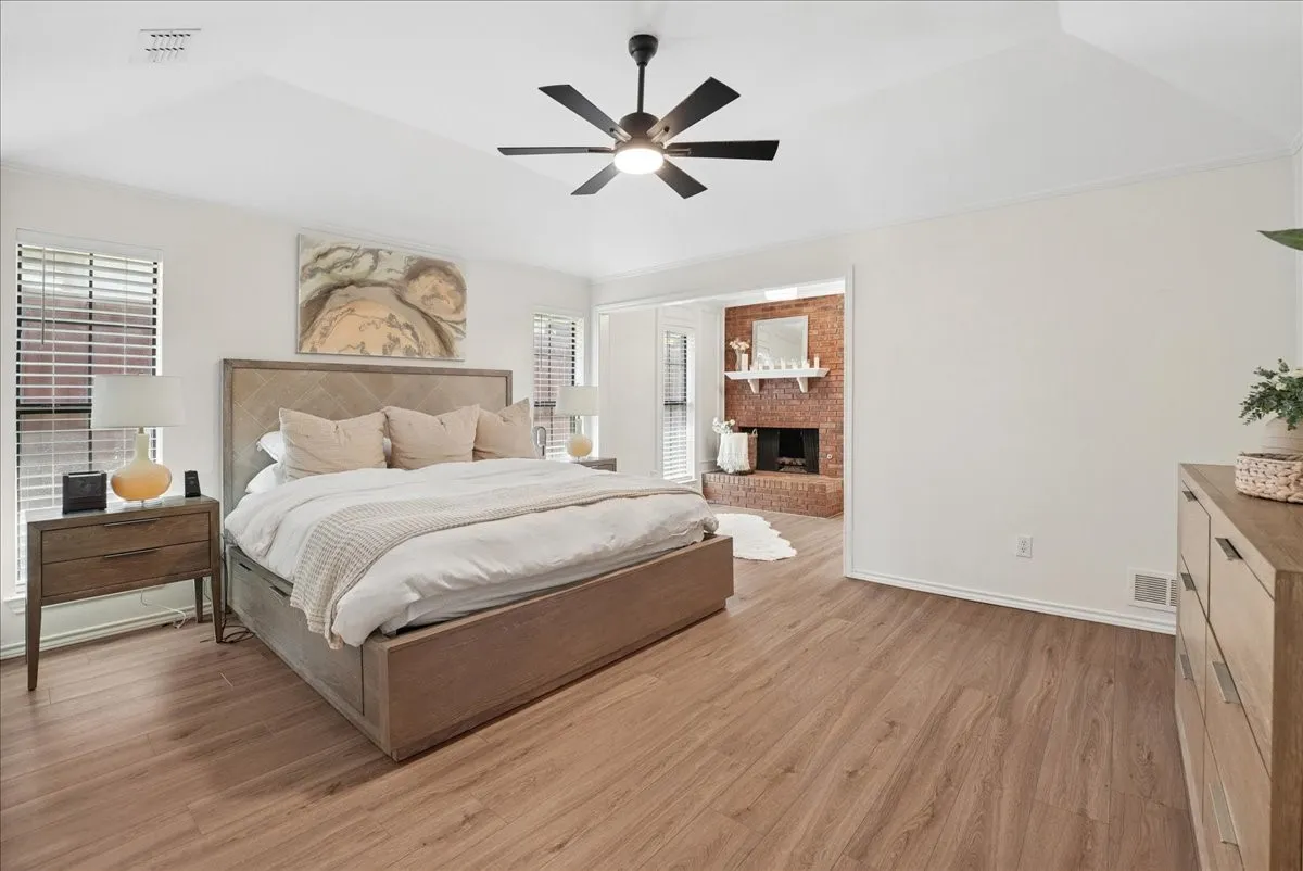 Spacious room featuring wood-finish flooring, a vaulted ceiling, and a ceiling fan
