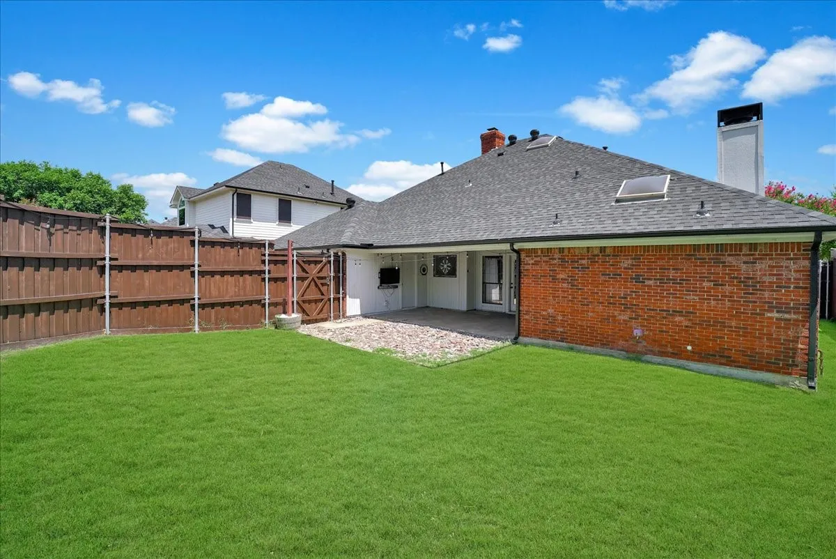 Expansive green lawn with a wood privacy fence