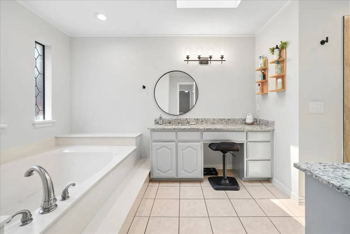 Soaking tub with chrome fixtures and a patterned privacy window