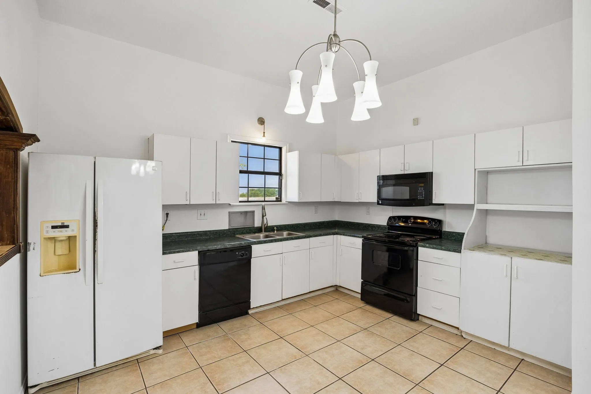 Electric slide in range with microwave above, dishwasher and Refrigerator all convey.