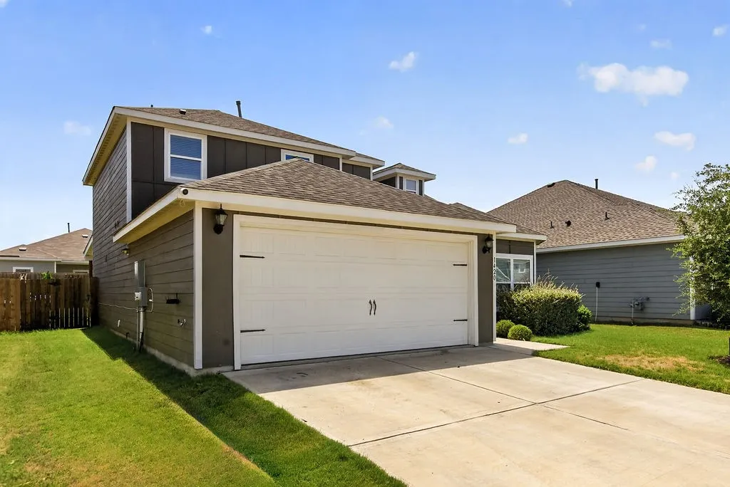 Two-story residence featuring a two-car garage with a concrete driveway