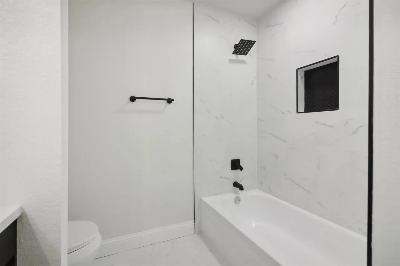 Bathtub and shower combination featuring black matte fixtures
